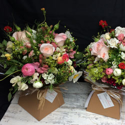 a pair of boxed gift bouquets with early summer blooms